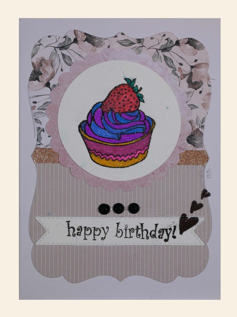 Ozdobna kartka. W centralnym miejscu ciastko - babeczka, obok napis: „happy birthday”.
