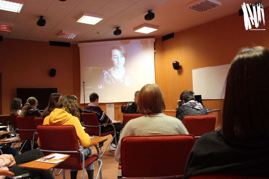Audytorium Biblioteki Głównej w Jaworznie, grupa uczestników siedzi przodem do dużego ekranu, na którym prezentowany jest materiał udostępniony przez prowadzącą wykład.